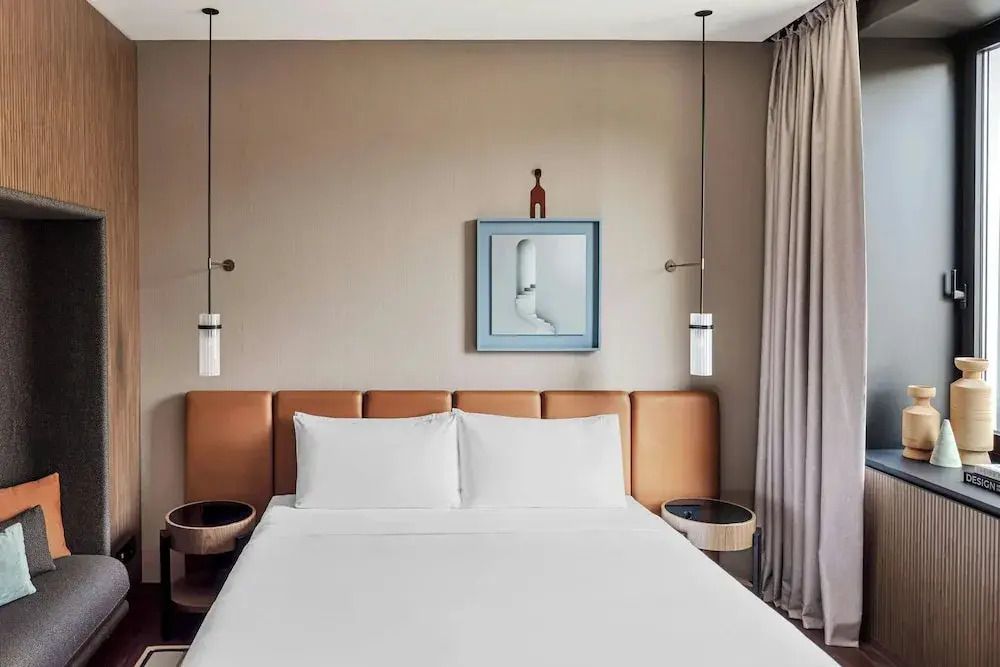 Gemütliches Doppelbett mit eleganter Beleuchtung im Hotelzimmer
