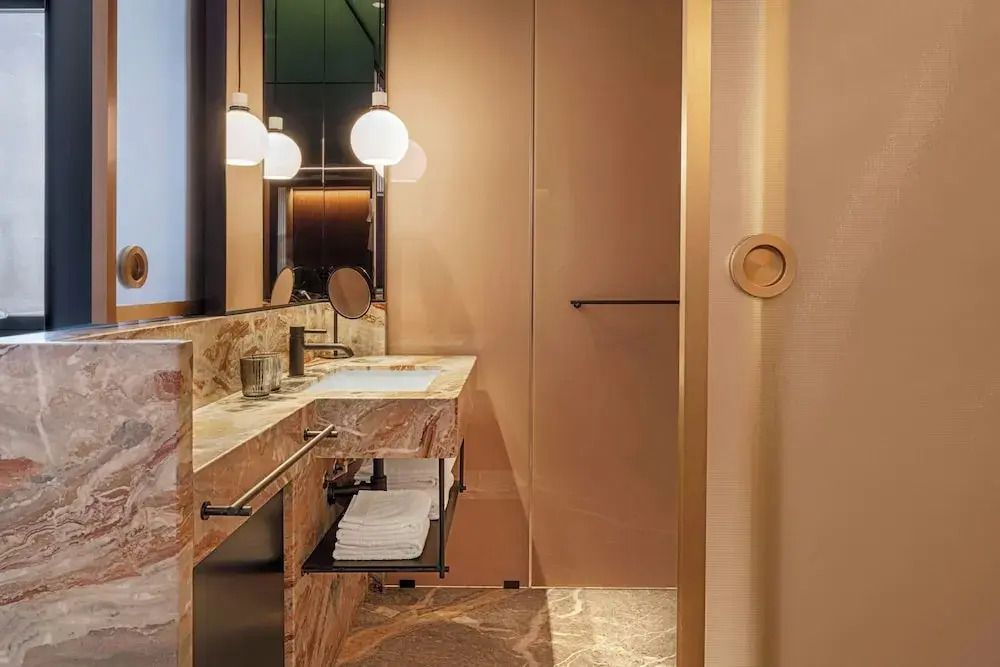 Luxuriöses Badezimmer im Hotel mit Marmorwaschtisch und eleganter Beleuchtung
