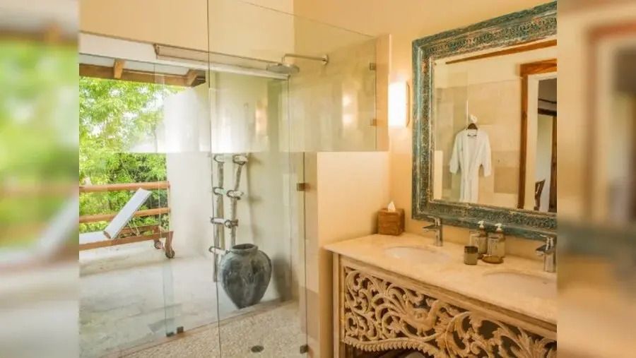 Elegantes Badezimmer mit Glasdusche und dekorativem Spiegel