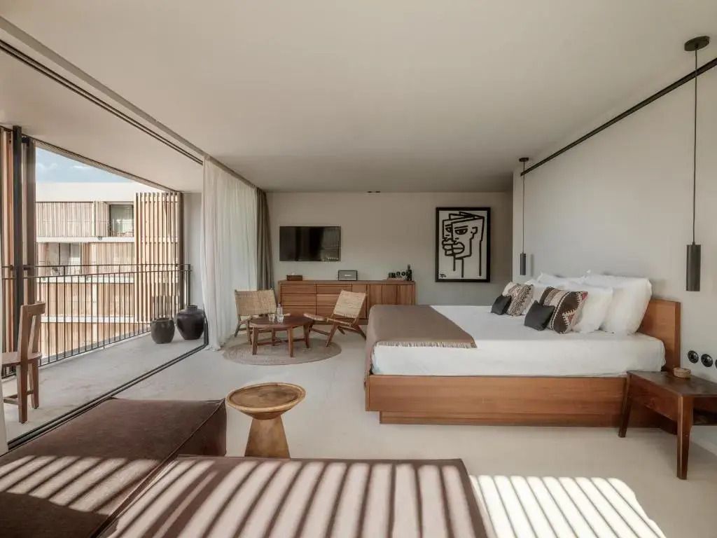 Helles Schlafzimmer mit Doppelbett und Balkon in der Deluxe Doppel Junior-Suite