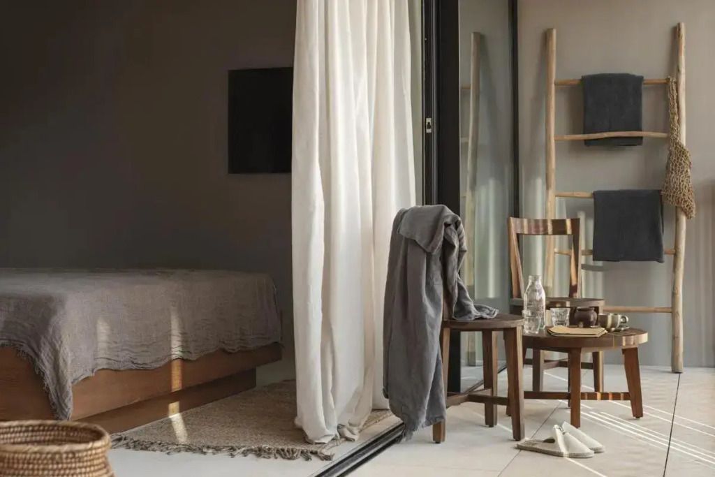 Helles Zimmer mit Doppelbett und Balkon mit stilvollen Holzmöbeln