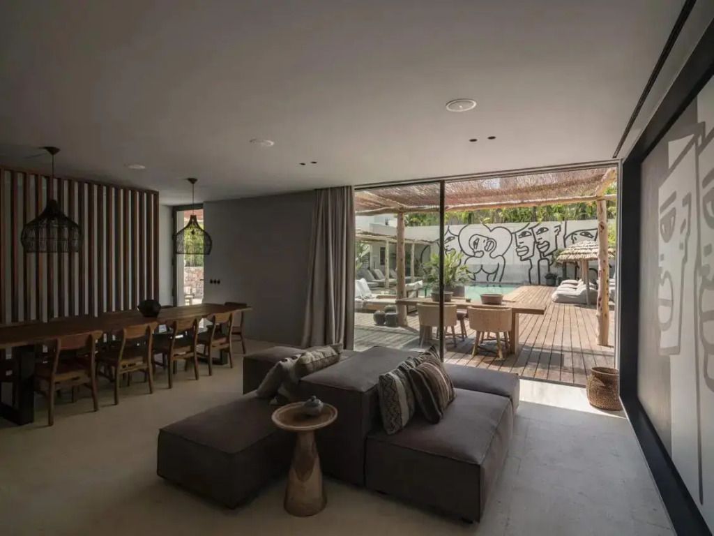 Offener Wohnbereich mit Sofa und Zugang zur Terrasse mit Graffiti-Wand