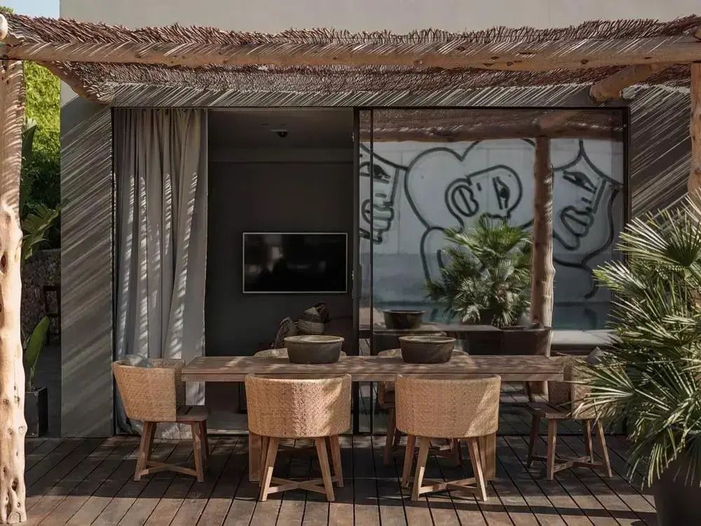 Essbereich auf der Terrasse mit Holztisch und Stühlen unter einer Pergola