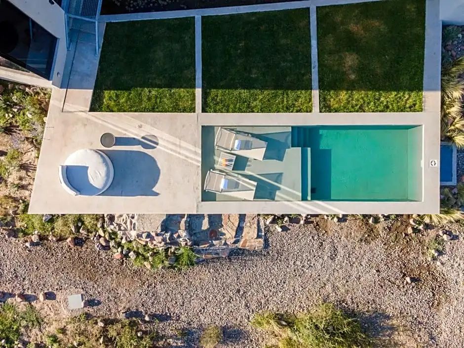 Privater Pool mit Liegestühlen und grüner Rasenfläche im Hotel Casa de Uco