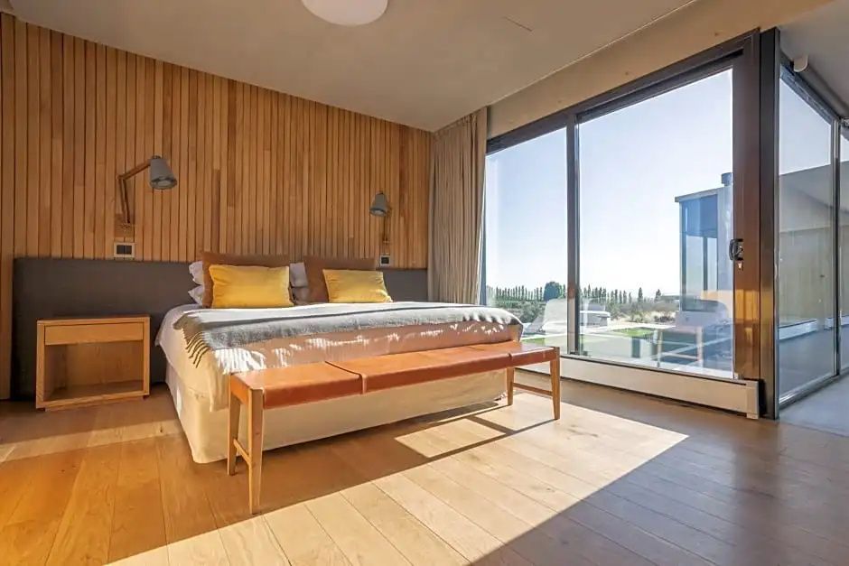 Modernes Doppelzimmer mit großem Fenster und heller Inneneinrichtung