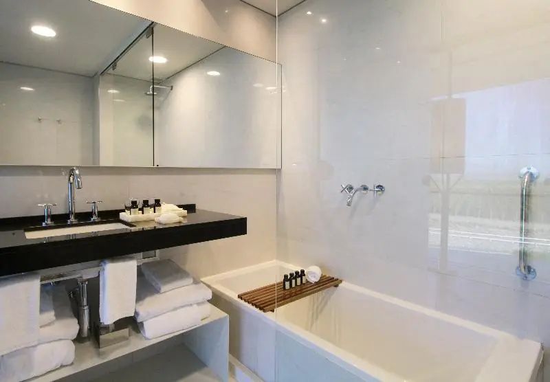 Elegantes Badezimmer mit großflächigem Spiegel und Badewanne in der Luxus Suite