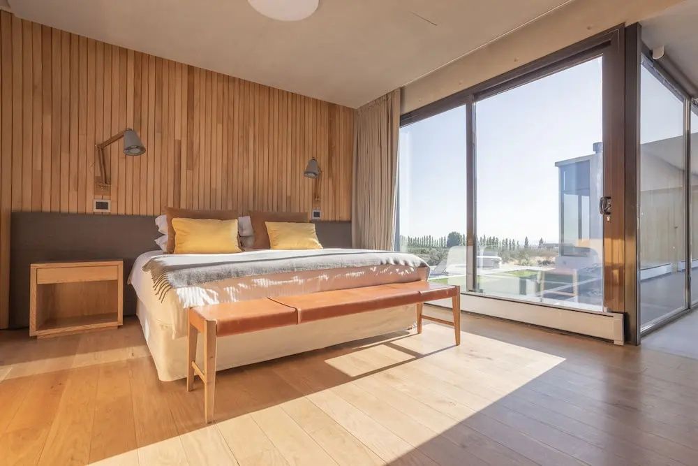 Luxus Zimmer mit Holzverkleidung und großem Fenster mit Weitblick