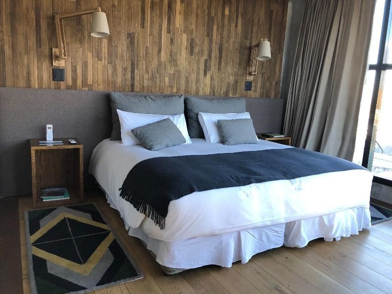Komfortables Schlafzimmer mit Holzakzentwand und großzügigem Doppelbett in der Premium Villa