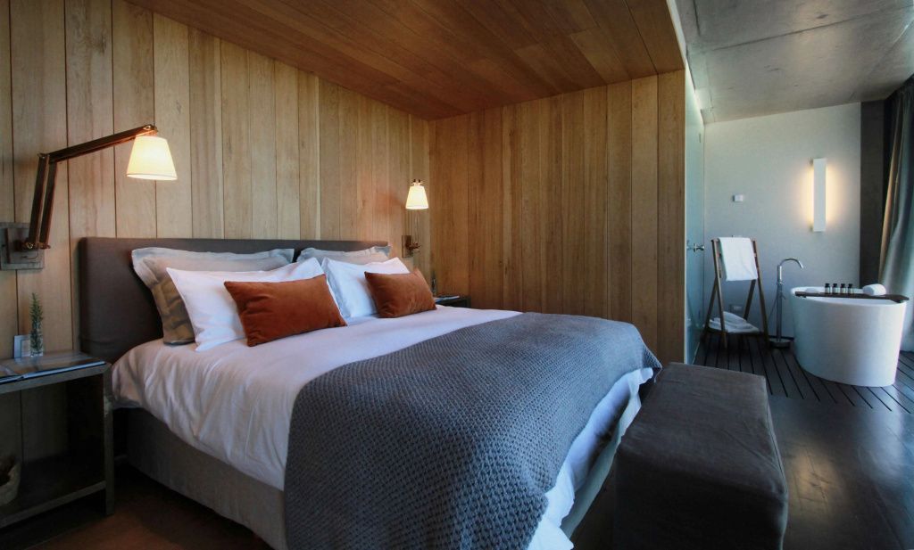Hochwertiges Bett mit Holzelementen und stimmungsvoller Beleuchtung.