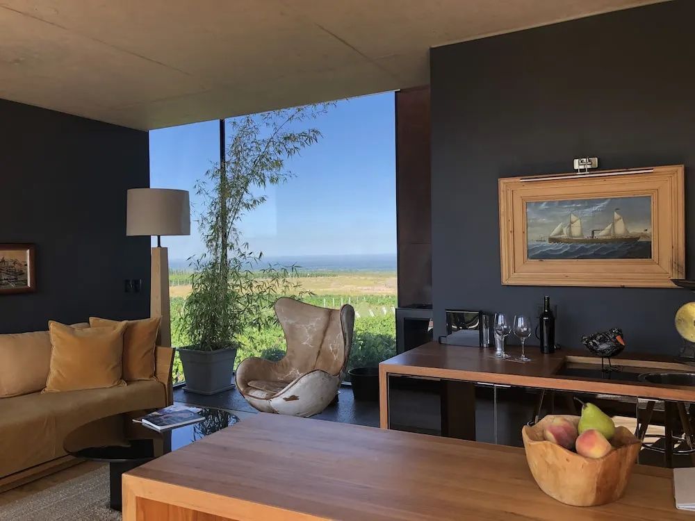 Eleganter Wohnbereich mit großem Fenster, Designermöbeln und Aussicht auf die Landschaft