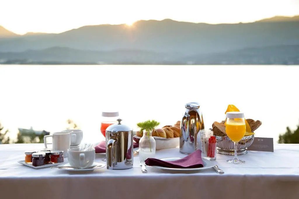 Frühstückstisch mit Meerblick und Sonnenaufgang im Hintergrund