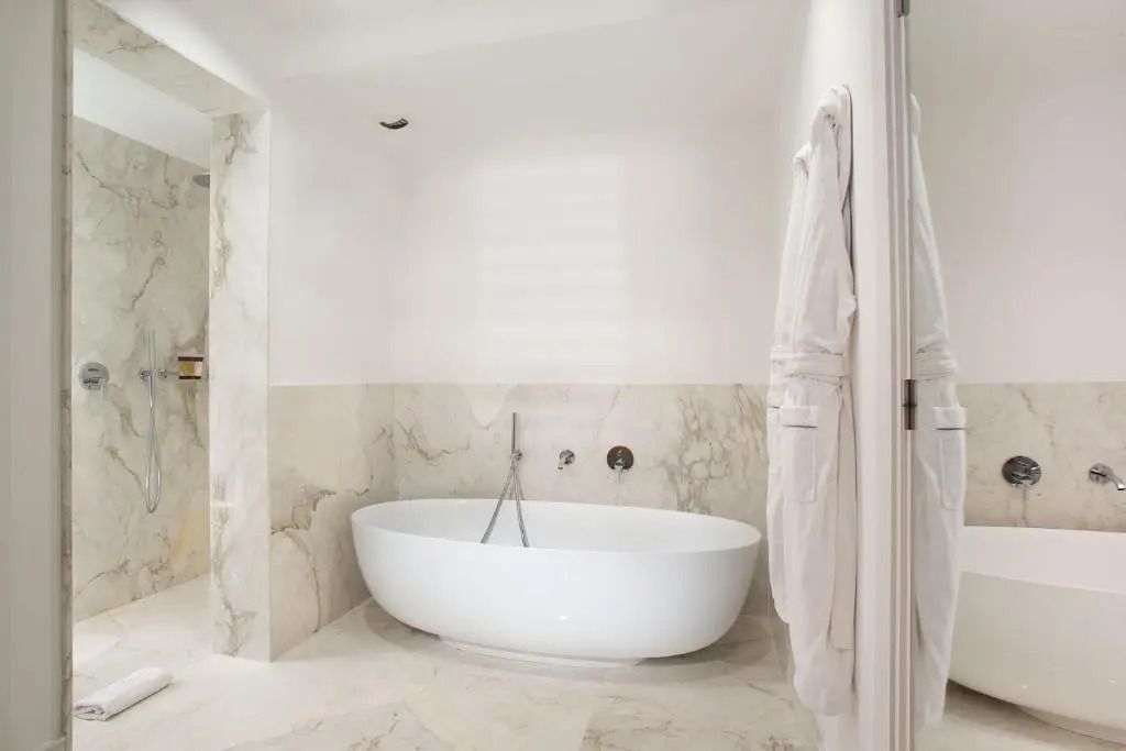 Luxuriöses Badezimmer mit freistehender Badewanne und Marmorfliesen