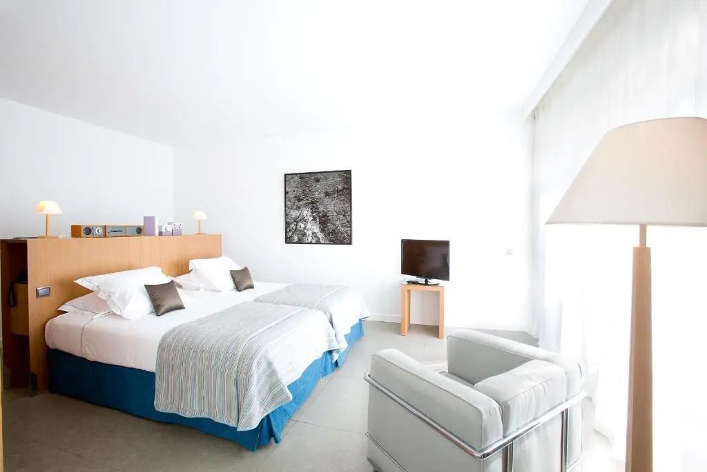 Helles Schlafzimmer mit zwei Doppelbetten und moderner Einrichtung