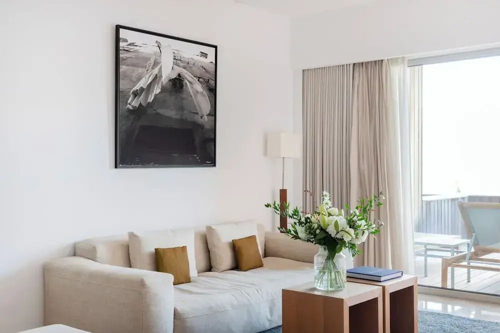 Elegantes Wohnzimmer mit Kunstwerk an der Wand und frischen Blumen