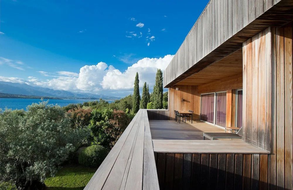 Moderne Holzarchitektur mit Ausblick auf Garten und Meer