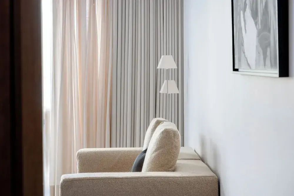 Elegantes Zimmer mit bequemen Sofas und großen Vorhängen