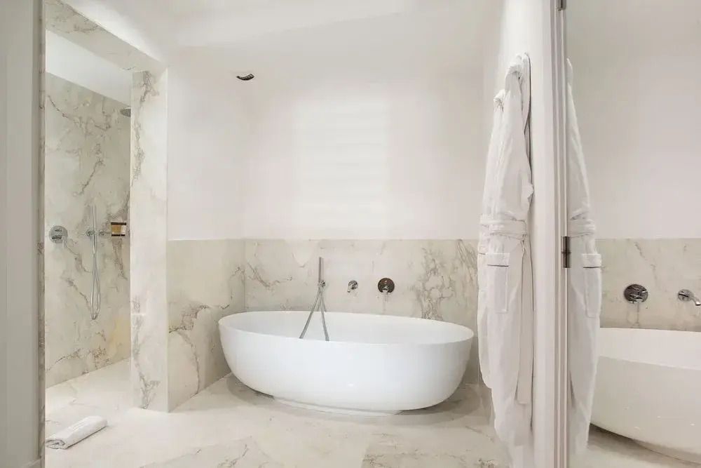 Luxuriöses Badezimmer mit freistehender Badewanne und Marmorwänden