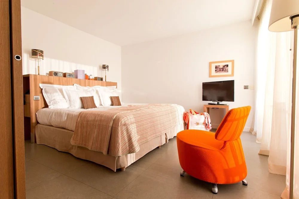 Junior-Suite mit Doppelbett und orangefarbenem Sessel
