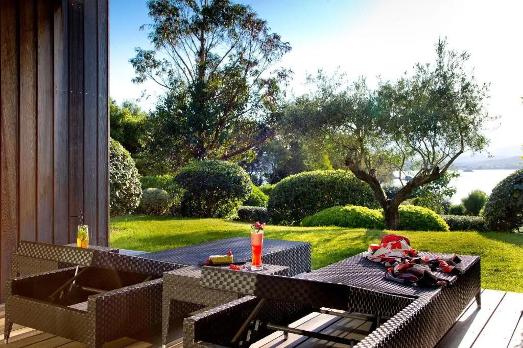 Gemütliche Terrasse mit Lounge-Möbeln und grüner Gartenlandschaft