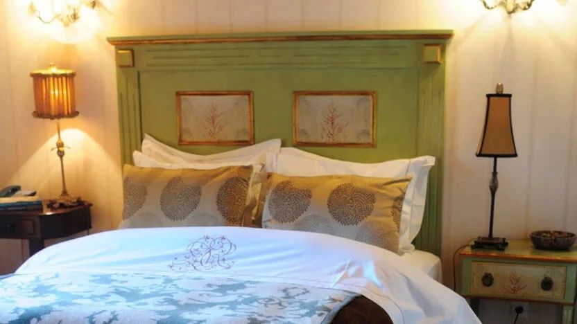 Gemütliches Schlafzimmer mit dekorativem Kopfteil und luxuriöser Bettwäsche