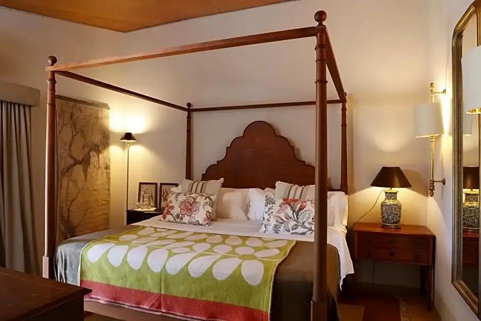 Elegantes Schlafzimmer mit Himmelbett und farbenfrohen Kissen