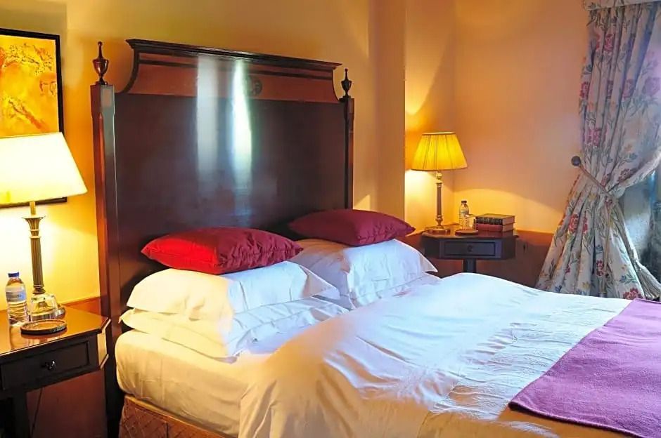 Elegantes Doppelbett mit roter und weißer Bettwäsche in einem einladenden Schlafzimmer