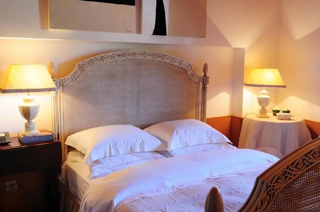 Wunderschönes Schlafzimmer mit geschnitztem Holzbett und weicher Beleuchtung