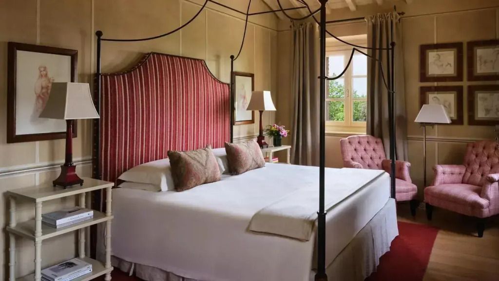 Elegantes Schlafzimmer der Alba Villa mit Himmelbett und rotem Kopfteil neben einem Fenster