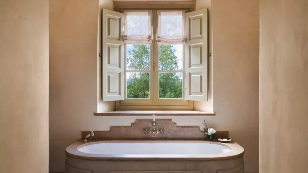 Modernes Badezimmer mit freistehender Badewanne und großem Fenster in der Biondi Villa