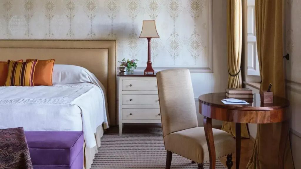 Elegantes Schlafzimmer mit Doppelbett, Nachttischlampe und klassischem Dekor