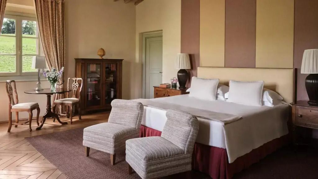 Geräumiges Schlafzimmer mit Kingsize-Bett und eleganten Sesseln in der Casa del Fiume Villa