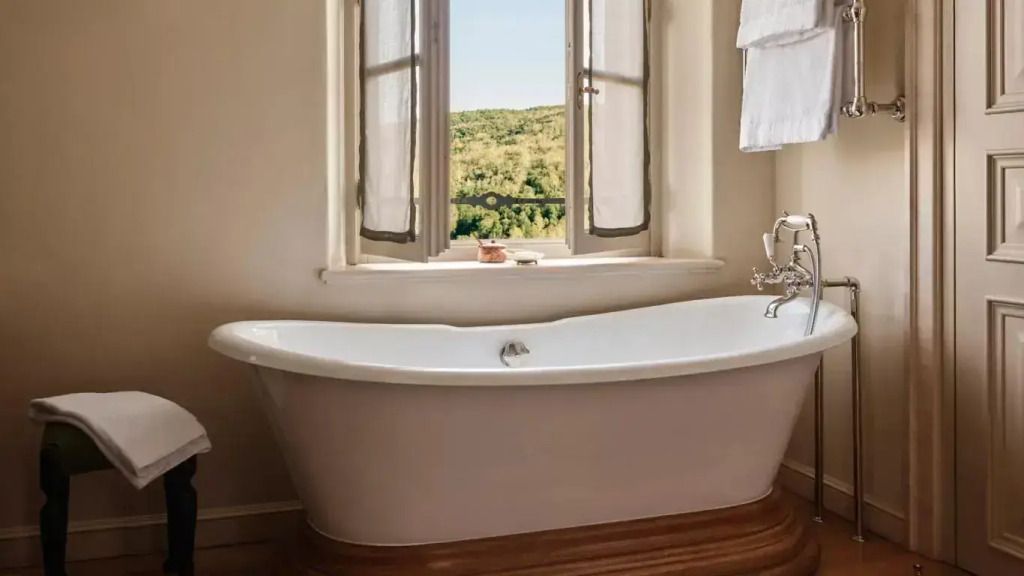 Freistehende Badewanne vor einem Fenster mit schöner Aussicht