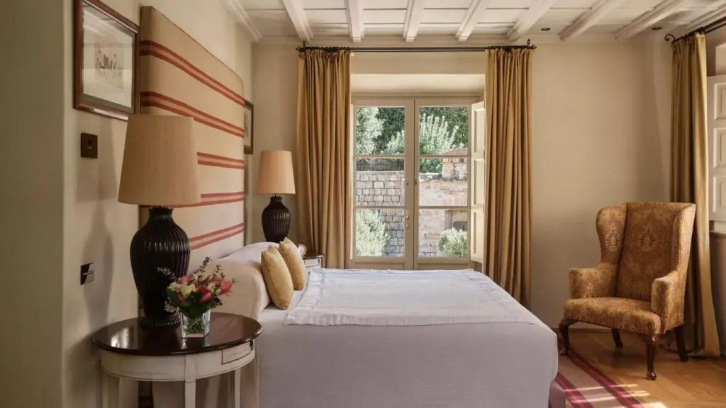 Helles Schlafzimmer mit offenem Fenster und klassischer Einrichtung.