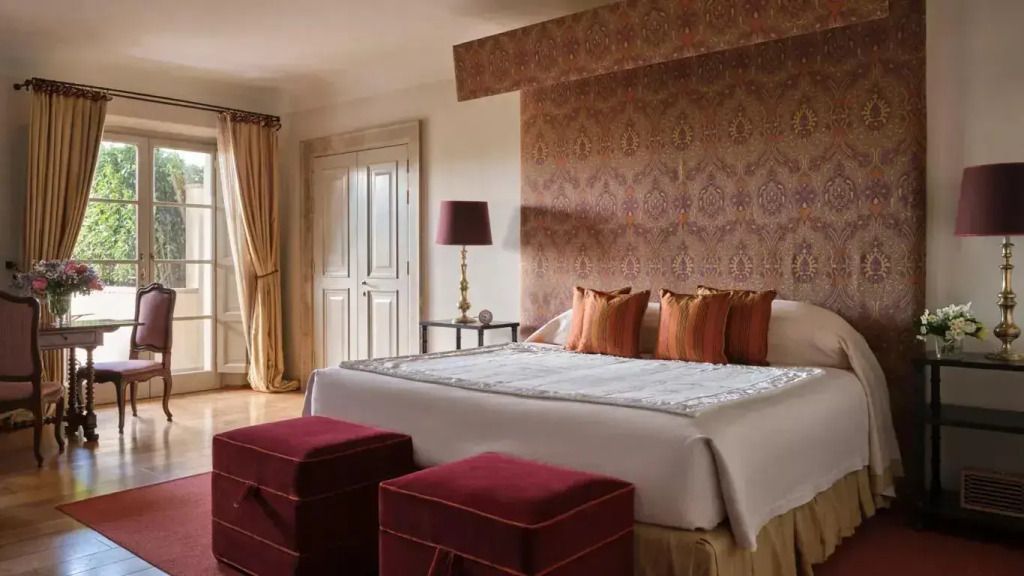 Elegantes Schlafzimmer mit Doppelbett und dekorativen Kissen in warmen Tönen.