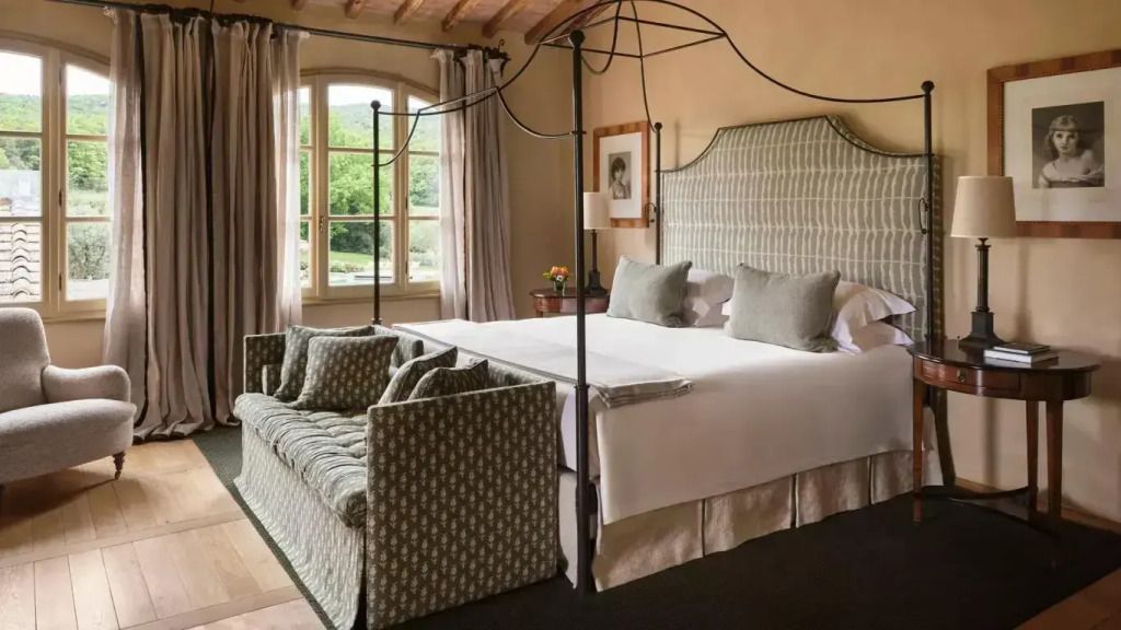 Elegantes Schlafzimmer mit Himmelbett und gemütlichem Sofa. Ausblick auf die Natur.