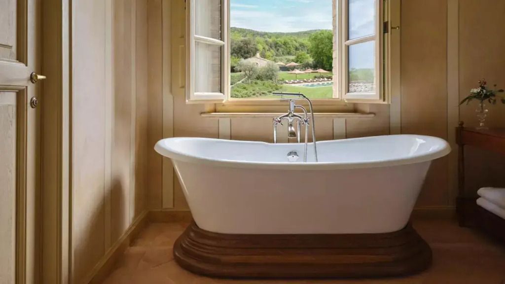 Freistehende Badewanne mit Panoramablick auf die toskanische Landschaft.