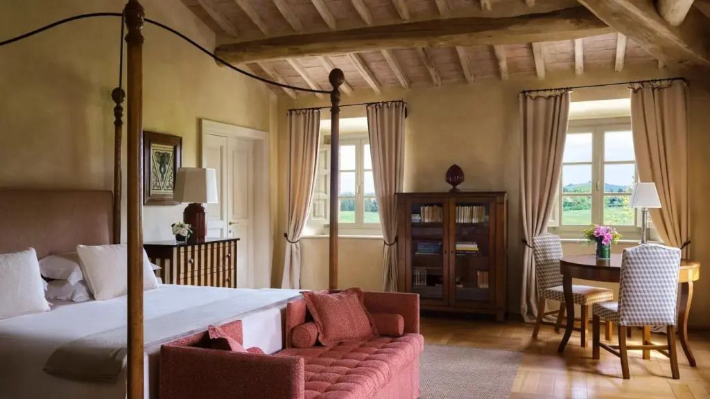 Geräumiges Wohnzimmer mit Holzbalkendecke, Sofa und Bücherregal.