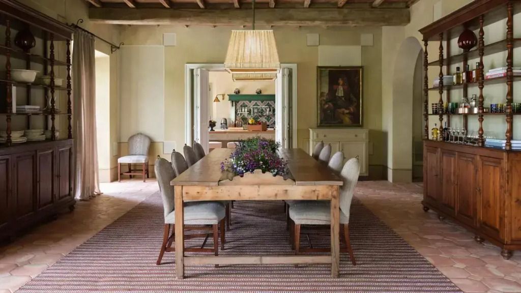 Esszimmer mit rustikalem Holztisch, Stühlen und eleganter Beleuchtung.