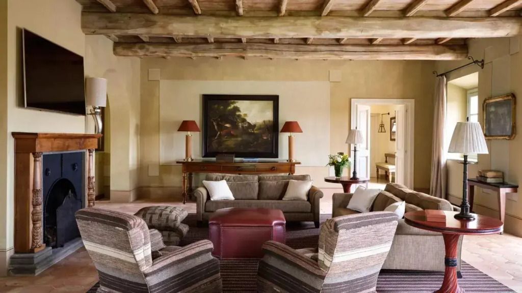 Gemütliches Wohnzimmer mit Sesseln, Sofa und kunstvoller Decke.