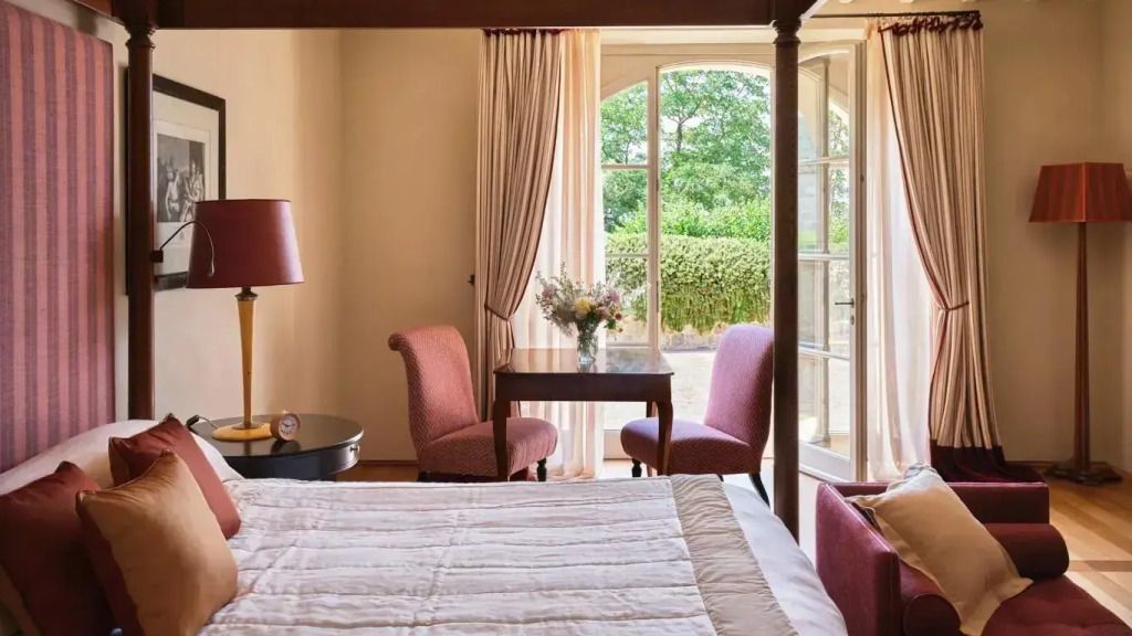 Gemütliche Terrasse Doppel Suite mit Doppelbett und eleganten Sitzmöbeln mit Blick nach draußen