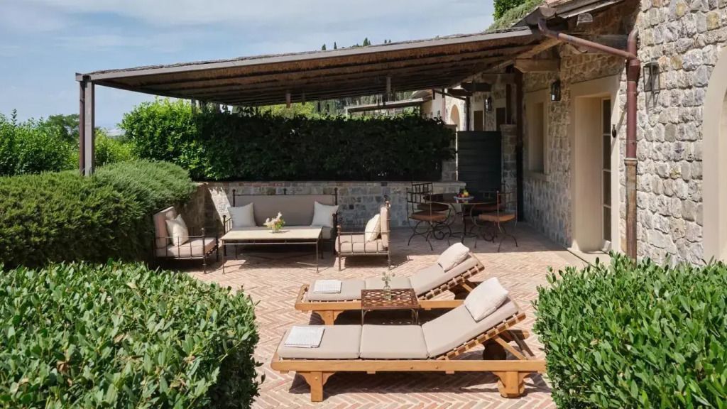 Einladende Terrasse mit bequemen Liegestühlen und Sitzbereich im Freien, umgeben von grüner Hecke