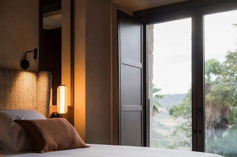 Doppelzimmer mit offenem Fenster und Blick auf die Landschaft