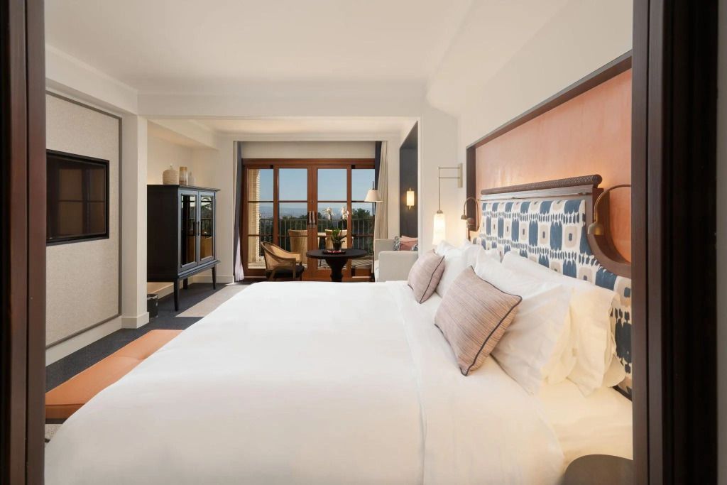Geräumiges Deluxe-Doppelzimmer mit modernem Interieur und Balkonblick auf die Bucht.