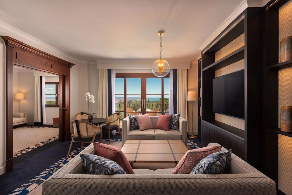 Luxuriöses Wohnzimmer der Deluxe Suite mit Meerblick und stilvoller Einrichtung.