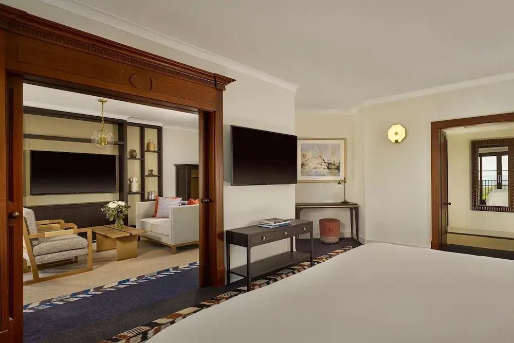 Wohnbereich der Deluxe Suite mit modernem Design und Verbindung zum Schlafzimmer.