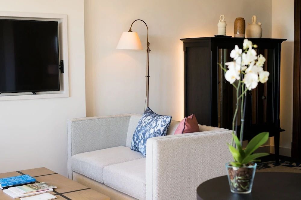 Gemütlicher Sitzbereich mit Couch und Dekoration in neutralen Farben in der Suite.