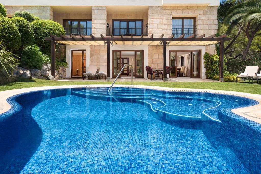 Privater Pool vor einer luxuriösen Villa mit Steinarchitektur und Terrasse