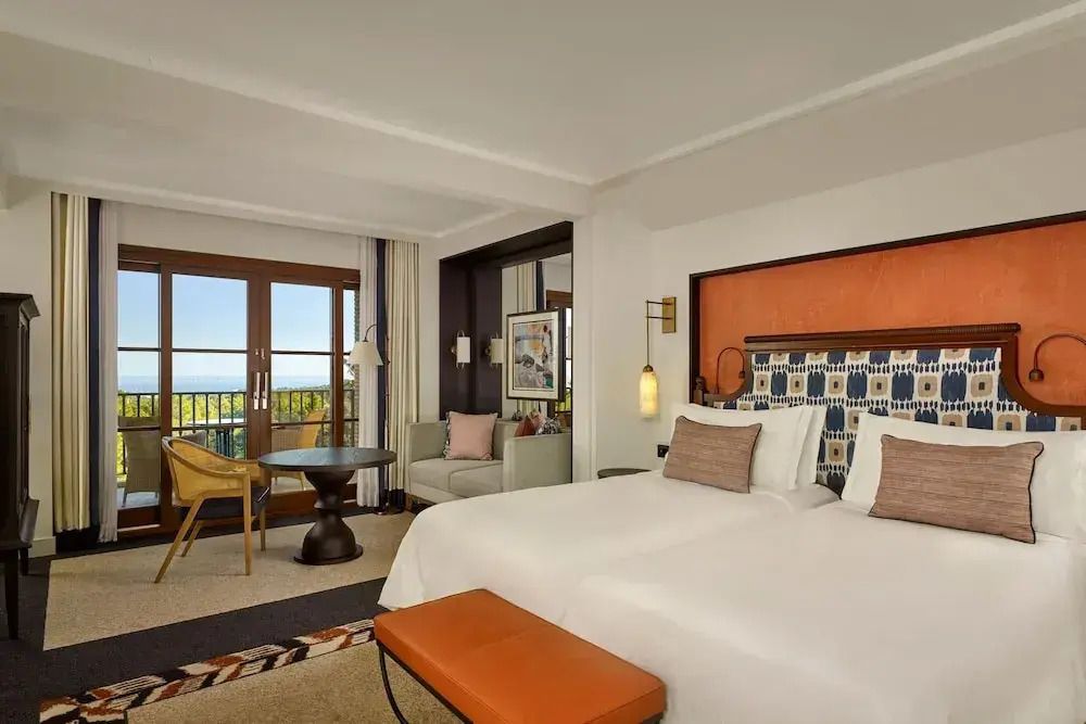 Geräumiges Grand Doppelzimmer mit elegantem Doppelbett und Balkon mit Meerblick.