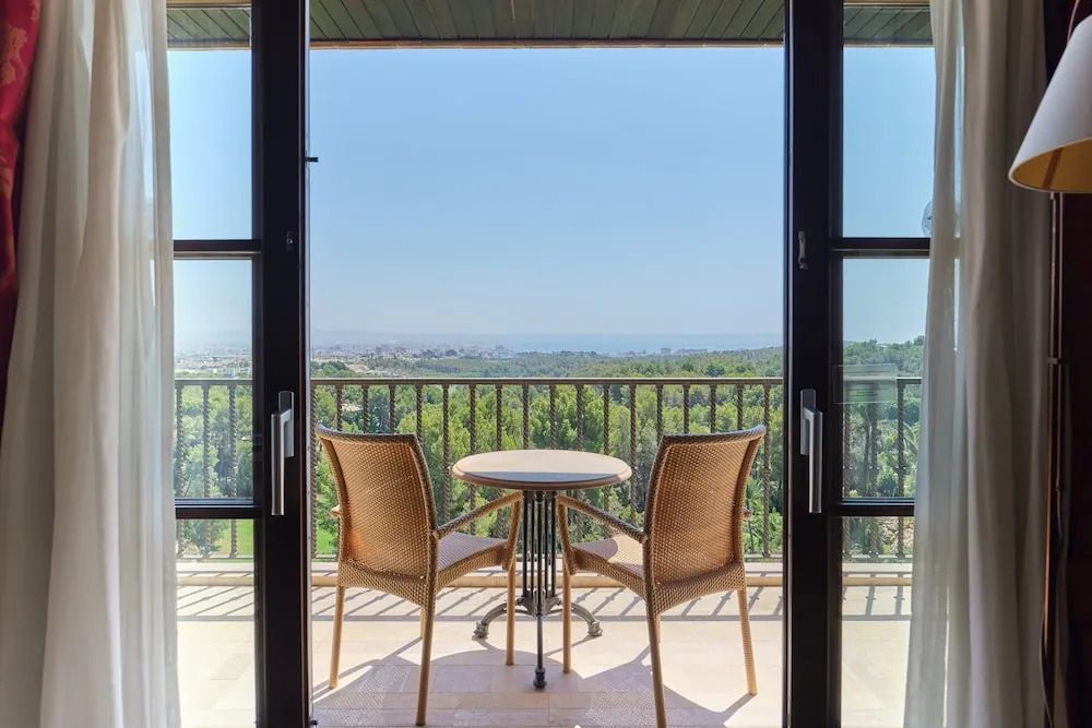 Sitzbereich auf dem Balkon mit Tisch und herrlichem Blick auf die Landschaft und das Meer.