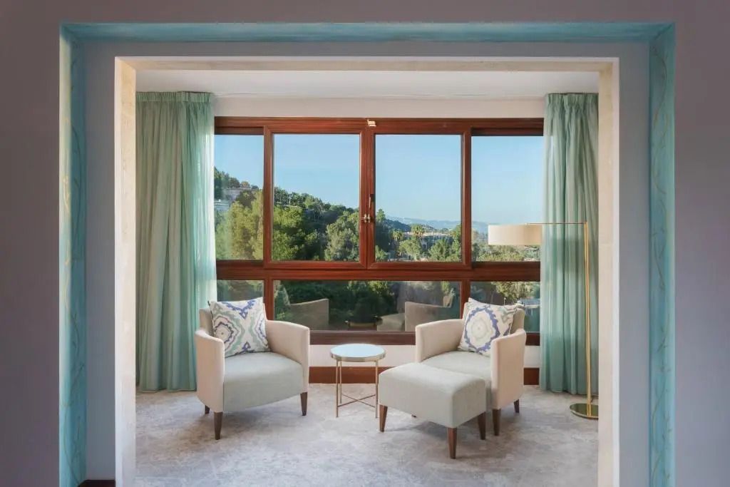 Zimmer im Castillo Hotel mit großen Fenstern und gemütlichen Sesseln